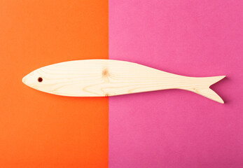 Figurine of horse mackerel carved from solid pine by hand jigsaw. On a multi-colored background