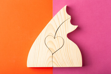 A figurine of hugging cats, carved from solid pine by a hand jigsaw. On a multi-colored background