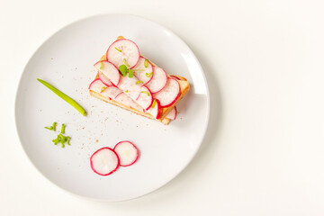 Toasted toast with fresh chopped radishes and green herb on the white plate. Healthy breakfast. Sandwich with vegetable.