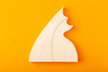 A figurine of hugging cats, carved from solid pine by a hand jigsaw. On a yellow background