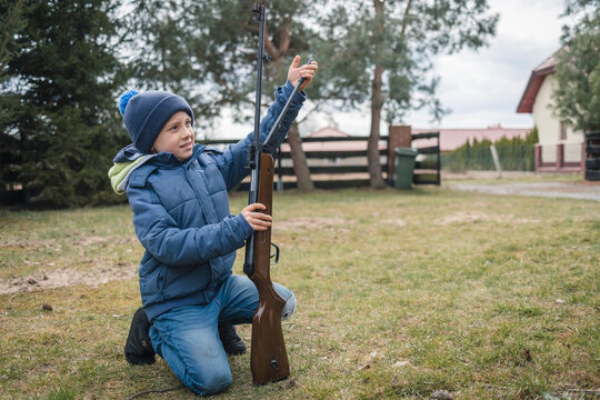 Young boy loading the air rifle