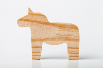 A figurine of a horse or unicorn, carved from solid pine with a hand jigsaw. On a white background