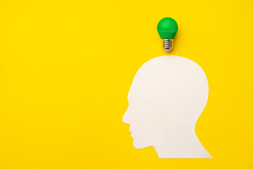 Papercut head and light bulb on paper background