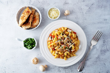 Roasted chicken mushroom pepper pasta in a white plate