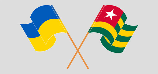 Crossed and waving flags of Ukraine and Togo