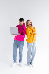 Fototapeta na wymiar Beautiful man and woman on white background using laptop and smartphone