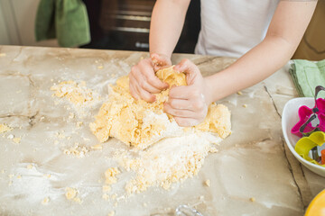 Obraz na płótnie Canvas Child's hands kneading dough at home in the kitchen. Cooking at home