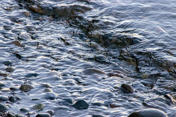 small waves flowing in over rocky shoreline