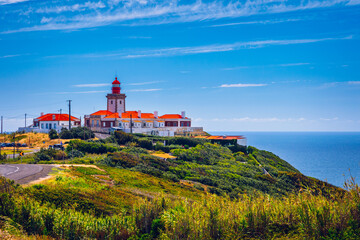 Fototapeta na wymiar The lighthouse in Cabo da Roca. Cliffs and rocks on the Atlantic ocean coast in Sintra in a beautiful summer day, Portugal. Cabo da Roca, Portugal. Lighthouse and cliffs over Atlantic Ocean.