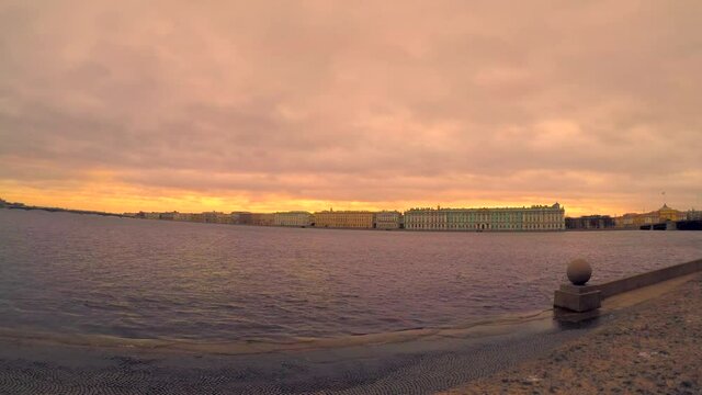 Time lapse video of beautiful sunrise sky above Saint Peterburg city and Neva river in Russia. Orange sky reflects in water. 4K resolution video. Travel in Russia theme.