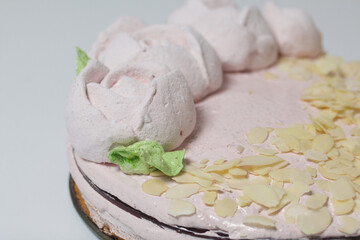Marshmallow cake. Layers of biscuit, marshmallow and jelly. Decorated with marshmallow roses and almond petals.