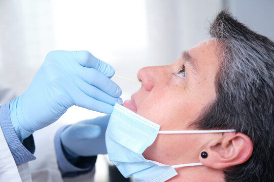 Close up of mature woman getting PCR test at doctor's office during coronavirus pandemic. Nasal coronavirus test. - Powered by Adobe