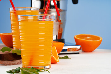 Glass of orange juice with red straw on table