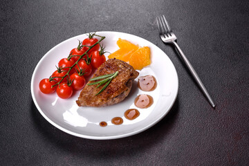 Baked duck breast with herbs and spices on a dark concrete background