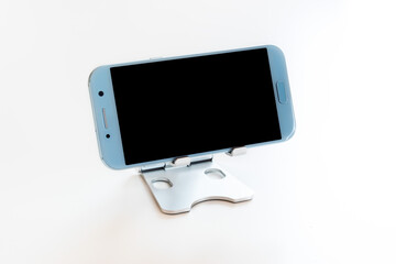 Close up of a device to support the mobile phone. Copy space available for advertising. Two cell phones placed opposite each other with a completely black screen.