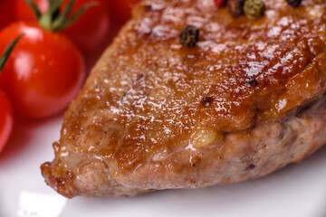 Baked duck breast with herbs and spices on a dark concrete background