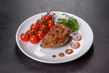 Baked duck breast with herbs and spices on a dark concrete background