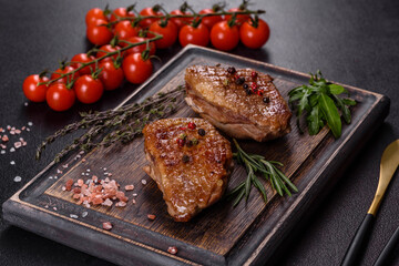 Baked duck breast with herbs and spices on a dark concrete background