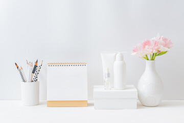 Home interior with decor elements. Mockup white desk calendar and pink tulips in a vase on a light background