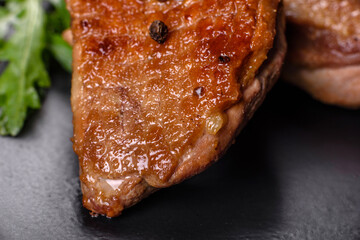 Baked duck breast with herbs and spices on a dark concrete background