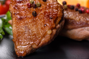 Baked duck breast with herbs and spices on a dark concrete background