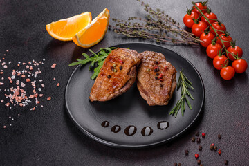Baked duck breast with herbs and spices on a dark concrete background