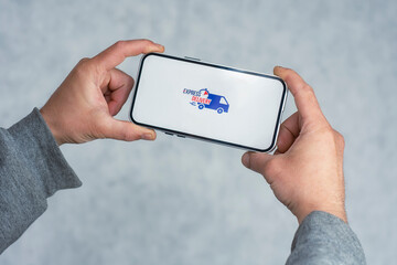 Express delivery in your phone. A man holds a smartphone with an icon on a white screen in his hands.