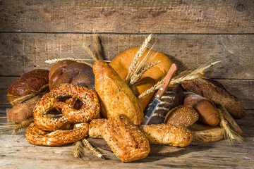 Assortment of various delicious freshly baked bread, on wooden rustic background copy space