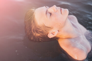 young teenage boy swimming in oceans water