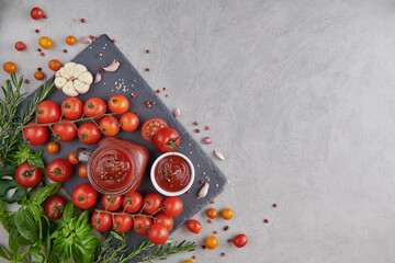 tomato sauce with garlic and  vibrant green leaves of the italian parsley plant. tomato ketchup sauce in a bowl with spices, herbs and cherry tomatoes. top view.