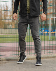 Young fashion man's legs with black sneakers. Black shoes