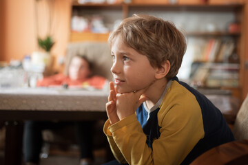 Chceerful young boy portrait during watching TV