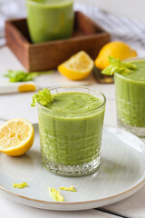Healthy green smoothie in a glass of spinach, mango, celery, ginger and lemon juice. Raw vegan food...