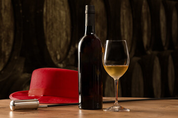 Bottle and glass of fino white sherry wine in winery with typical Jerez with Venetian and red hat