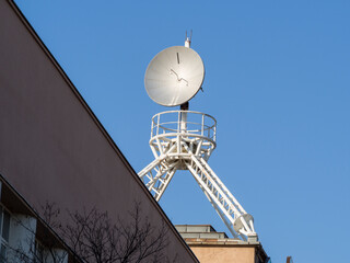 Large satellite antenna with construction stands on a roof