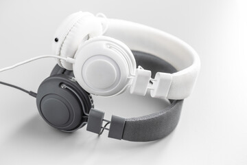 White and black wired stereo headphones on gray background.