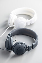 Fototapeta na wymiar White and black wired stereo headphones on gray background.