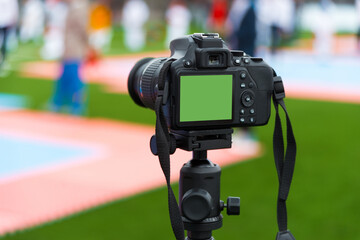 Photo of camera with green screen filming competition on arena