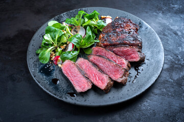 Modern style traditional dry aged sliced wagyu roast beef with corn salad and pine nuts served as...