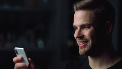 Close up of handsome man using smartphone for watching video.