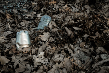 Obraz premium Environmental pollution. Waste rubbish in forest. Plastic garbage trash in woodland. Ecological problem with Empty used dirty plastic bottles.