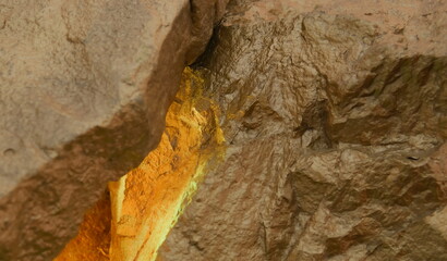 A Depiction of a Golden Rock, Showing the Metallic Painted Texture of the Stone with a Blurred Mineral Foreground.