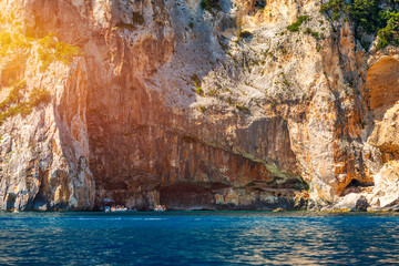 Fototapeta na wymiar Blue sea and the characteristic caves of Cala Luna, a beach in the Golfo di Orosei, Sardinia, Italy. Big sea caves in the mediterranean coast. Sardinia, Italy.