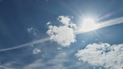 Naklejka na ściany i meble clouds and contrails in sunny blue sky
