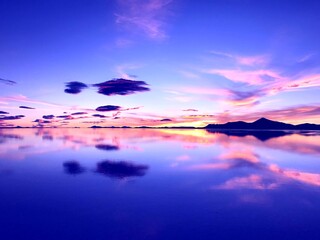 Sunset over lake. Wonderful sunset in mountains. Surreal natural landscape at salt flat Salar de...