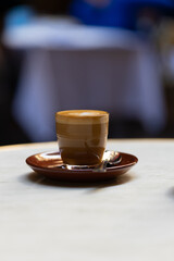 decorated glass of Coffee Piccolo Latte on a white table in a Sydney Cafe NSW Australia