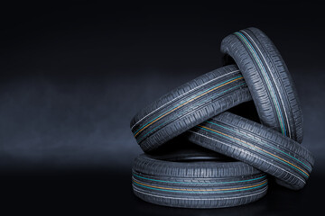 Stack of four summer car tires on creative background