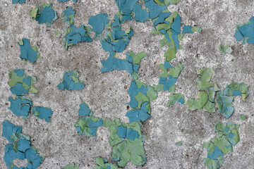 Peeling paint on the wall. Old concrete wall with cracked flaking paint. Weathered rough painted surface with patterns of cracks and peeling. Grunge texture for background and design. High resolution.