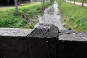 Wooden bridge fences on the small river in bursa covered by green grass.