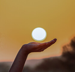 His child's hand holds the sun
